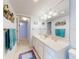 Bright bathroom featuring a white vanity, a large mirror, and beach-themed decor at 5201 S Atlantic Ave # 407A, New Smyrna Beach, FL 32169