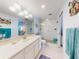 Bathroom featuring white cabinets, a glass shower, and beach-themed decorations at 5201 S Atlantic Ave # 407A, New Smyrna Beach, FL 32169