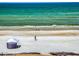 Serene beach view with people enjoying the water and sandy shore, under a sunny sky at 5201 S Atlantic Ave # 407A, New Smyrna Beach, FL 32169