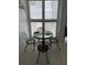 Cozy breakfast nook with a glass table, four chairs, and natural light at 5201 S Atlantic Ave # 407A, New Smyrna Beach, FL 32169