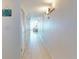 A hallway features storage closets, neutral walls, tile flooring, and an ocean view in the distance at 5201 S Atlantic Ave # 407A, New Smyrna Beach, FL 32169