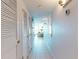 A hallway features storage closets, neutral walls, tile flooring, and an ocean view in the distance at 5201 S Atlantic Ave # 407A, New Smyrna Beach, FL 32169