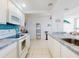 Bright kitchen with white appliances, tiled countertops, and an open view to the dining room at 5201 S Atlantic Ave # 407A, New Smyrna Beach, FL 32169