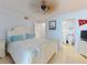 Comfortable main bedroom with tiled flooring, ceiling fan, dresser and ensuite bathroom at 5201 S Atlantic Ave # 407A, New Smyrna Beach, FL 32169