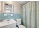 Charming bathroom features a tub and shower with stylish curtain, vanity with sink, and blue tile at 525 N Atlantic Ave # 39, New Smyrna Beach, FL 32169
