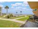 Exterior view of condo grounds featuring grassy area, mature palm trees and a view of the ocean in the distance at 525 N Atlantic Ave # 39, New Smyrna Beach, FL 32169