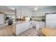 Bright kitchen with white cabinets and appliances, complemented by tiled floors and an adjacent dining area at 525 N Atlantic Ave # 39, New Smyrna Beach, FL 32169