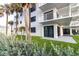 Building exterior with a patio and lawn, surrounded by lush greenery and palm trees at 5301 S Atlantic Ave # 140, New Smyrna Beach, FL 32169