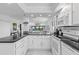 The kitchen with white cabinetry and black countertops features a bright, open design at 5301 S Atlantic Ave # 140, New Smyrna Beach, FL 32169
