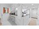 A bright kitchen features white cabinets, marble floors, and black counter tops with a breakfast bar at 5301 S Atlantic Ave # 140, New Smyrna Beach, FL 32169
