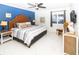 Comfortable bedroom with blue accent wall, patterned bedding, and coastal-inspired decor at 5301 S Atlantic Ave # 140, New Smyrna Beach, FL 32169