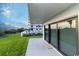Patio with sliding glass doors overlooking a manicured lawn and partial view of the ocean at 5301 S Atlantic Ave # 140, New Smyrna Beach, FL 32169