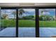 View from the patio overlooking a lush lawn, palm trees, and the ocean beyond at 5301 S Atlantic Ave # 140, New Smyrna Beach, FL 32169