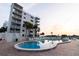 A sparkling pool with lounge chairs is situated next to a beachfront condo complex at 5301 S Atlantic Ave # 140, New Smyrna Beach, FL 32169