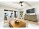 Bright living room with ceiling fan, wooden coffee table, water view from balcony, and comfortable seating at 5501 S Atlantic Ave # 4090, New Smyrna Beach, FL 32169