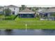 A spacious backyard on the water features lush lawn and a screened-in patio for outdoor enjoyment at 551 Armoyan Way, New Smyrna Beach, FL 32168