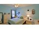 Bright bedroom with light blue walls, ceiling fan, and a large window, perfect for relaxation at 551 Armoyan Way, New Smyrna Beach, FL 32168