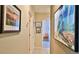 Inviting hallway featuring neutral paint, tile floors, and striking art pieces enhancing the home's ambiance at 551 Armoyan Way, New Smyrna Beach, FL 32168