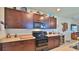 Kitchen view showcasing dark cabinetry, a flat-top stove, and granite countertops at 551 Armoyan Way, New Smyrna Beach, FL 32168