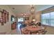 Cozy living area adjacent to the dining room with a chandelier and views of the screened porch at 551 Armoyan Way, New Smyrna Beach, FL 32168