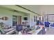 Spacious covered patio with lounge area, ceiling fan, and view of the sparkling pool at 551 Armoyan Way, New Smyrna Beach, FL 32168