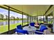 Screened patio boasts blue patio set and peaceful lake views, perfect for outdoor relaxation at 551 Armoyan Way, New Smyrna Beach, FL 32168