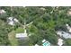 Aerial view showcasing the property, surrounding trees, the home with the pool, and the nearby neighborhood at 585 Corbin Park Rd, New Smyrna Beach, FL 32168