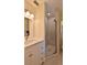 Bright bathroom featuring a glass shower and vanity with white cabinets and a sleek countertop at 585 Corbin Park Rd, New Smyrna Beach, FL 32168