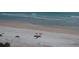 Aerial view of the beach features sunbathers enjoying the sunshine with colorful umbrellas at 585 Corbin Park Rd, New Smyrna Beach, FL 32168
