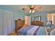 Serene bedroom with blue walls, wood floors, a ceiling fan, and wooden dressers at 585 Corbin Park Rd, New Smyrna Beach, FL 32168