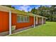 Charming single-story home with a brick and wood facade, lush lawn, and covered entryway providing curb appeal at 585 Corbin Park Rd, New Smyrna Beach, FL 32168