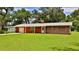 Charming home with brick accents, a well-manicured lawn, and an attached garage at 585 Corbin Park Rd, New Smyrna Beach, FL 32168