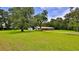Charming single-story home with a brick facade, lush lawn, mature trees, and an exterior shed at 585 Corbin Park Rd, New Smyrna Beach, FL 32168