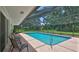 Inviting screened-in pool with a spacious deck and lush landscaping, perfect for outdoor entertaining and relaxation at 585 Corbin Park Rd, New Smyrna Beach, FL 32168