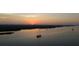 Sunset over a river, showcasing boats gently sailing on the calm water under a colorful sky at 585 Corbin Park Rd, New Smyrna Beach, FL 32168