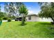 Expansive backyard featuring a green lawn, white fencing, and a screened-in patio for outdoor enjoyment at 5935 Shady Creek Ln, Port Orange, FL 32128