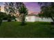 Spacious backyard featuring lush green grass, mature trees, and a charming screened lanai at 5935 Shady Creek Ln, Port Orange, FL 32128