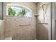 The bathroom features a shower with a window, tile walls, and accessible grab bars at 5935 Shady Creek Ln, Port Orange, FL 32128