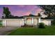Charming home featuring a two-car garage, arched windows, and a well-maintained lawn at 5935 Shady Creek Ln, Port Orange, FL 32128
