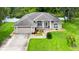 Well-maintained front exterior with a two-car garage, landscaped yard, and classic architectural details at 5935 Shady Creek Ln, Port Orange, FL 32128