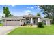 Charming single-story home with an attached garage, well-maintained lawn, and manicured landscaping at 5935 Shady Creek Ln, Port Orange, FL 32128