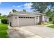 Attached two-car garage with a concrete driveway and manicured lawn in front of a single-story home at 5935 Shady Creek Ln, Port Orange, FL 32128
