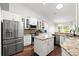 Bright kitchen features stainless steel appliances, granite counters, white cabinets, and center island at 5935 Shady Creek Ln, Port Orange, FL 32128