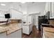 Open kitchen boasts stainless steel appliances, granite counters, white cabinetry, and center island at 5935 Shady Creek Ln, Port Orange, FL 32128