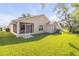 Exterior view of home featuring a well-manicured lawn, lanai, and mature trees at 620 Middlebury Loop, New Smyrna Beach, FL 32168