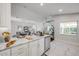 Open kitchen featuring white cabinetry, a stainless steel dishwasher and marble countertop at 620 Middlebury Loop, New Smyrna Beach, FL 32168