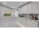Bright kitchen featuring white cabinets, marble countertops and backsplash, plus tile flooring at 620 Middlebury Loop, New Smyrna Beach, FL 32168