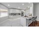 Modern kitchen with white cabinetry, marble countertops, stainless steel appliances, and sleek flooring at 620 Middlebury Loop, New Smyrna Beach, FL 32168