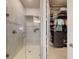 Bright bathroom featuring a walk-in shower with stone tile and a walk-in closet with custom shelving at 6307 Hanfield Dr, Port Orange, FL 32128