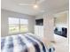 Bright bedroom with a white bed frame, blue and white bedding, and a tv on the dresser at 6307 Hanfield Dr, Port Orange, FL 32128